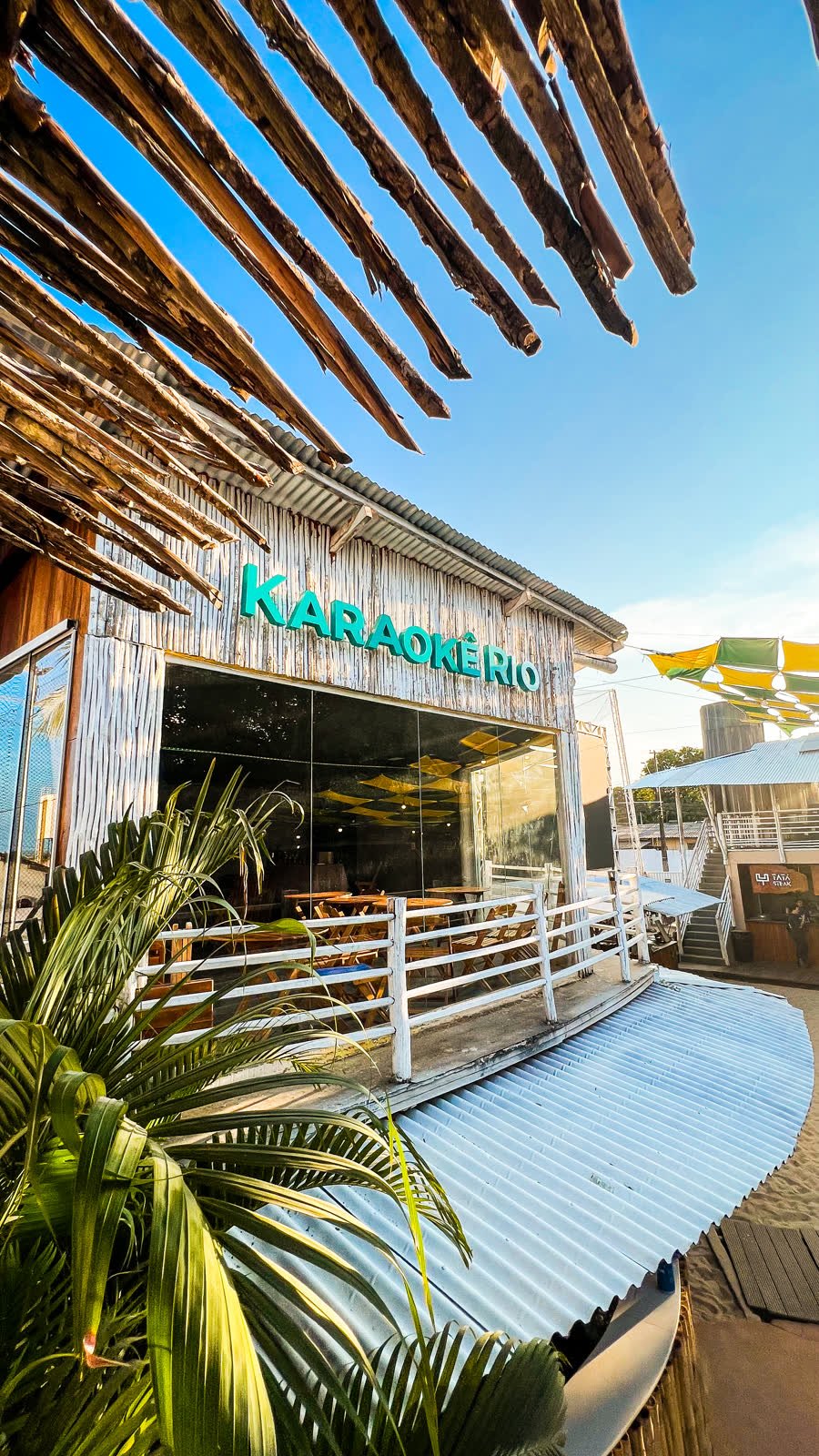 Fachada do Karaokê Rio no Rio Sand Club, com o letreiro verde e a varanda de madeira